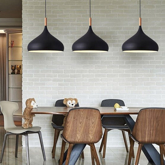 Three wooden pendant lights hanging above a kitchen island.